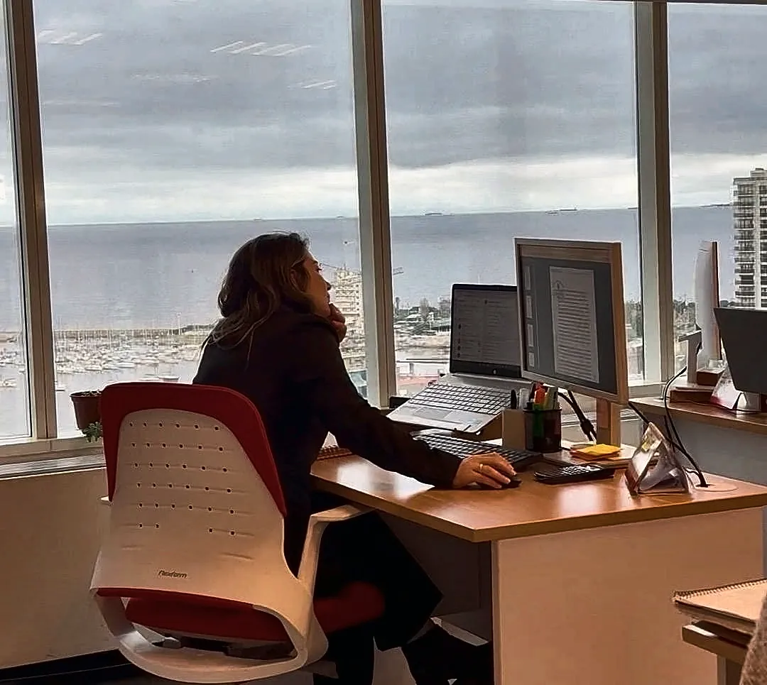 Integrante da VDC Estudio Contable na sua mesa, com vista para o porto do Buceo